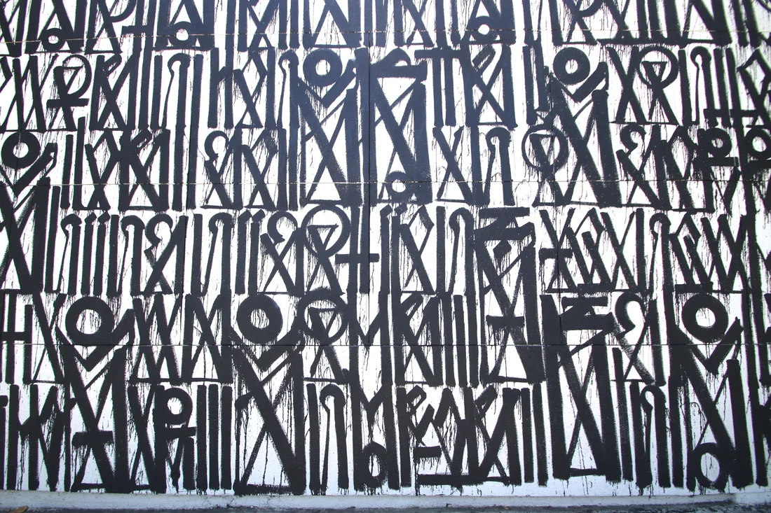 RETNA's monumental calligraphic mural — black script on white wall